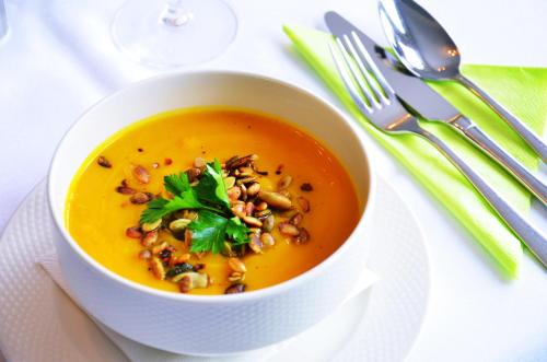 a bowl of soup with beans and parsley on a plate at Hotel Willa Odkrywców in Szklarska Poręba