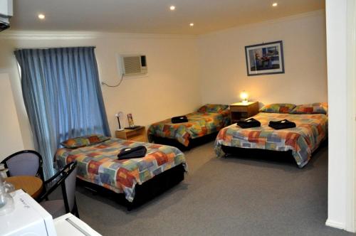 Säng eller sängar i ett rum på West City Motel