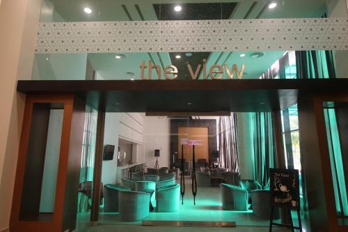 a waiting room with green chairs and a sign on the wall at Grand Riverview Hotel in Kota Bharu