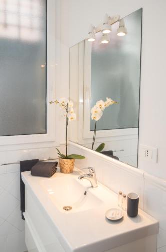a white bathroom with a sink and a mirror at Portobello Apartments in Bologna
