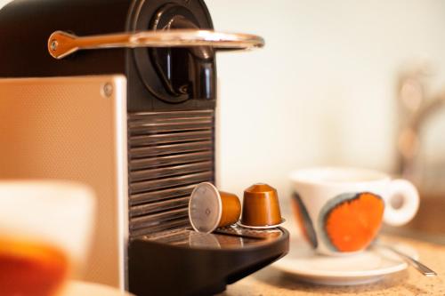 a coffee maker with spoons and a cup on a table at Apart Alpenblick in Pfunds
