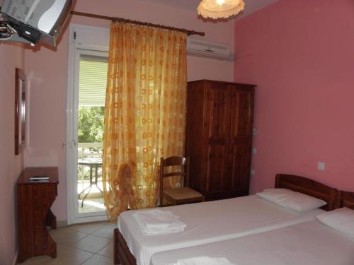 a bedroom with two beds and a window with a patio at Agyra Villa in Limenaria