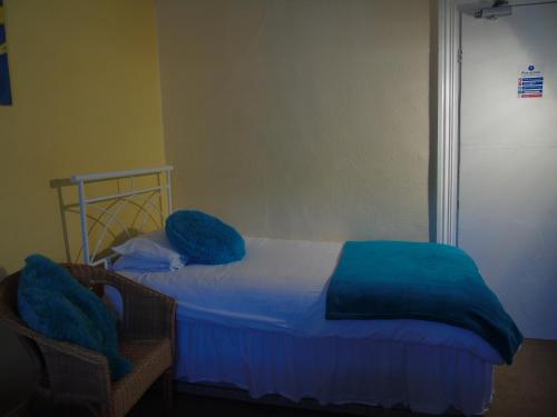 a bedroom with a bed with blue blankets on it at Victoria Guest House in Bedford