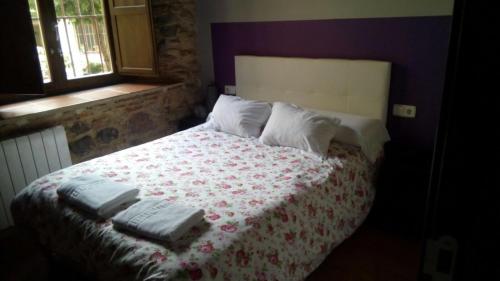 a bedroom with a bed with two towels on it at Hosteria Natura Plaza in Segovia