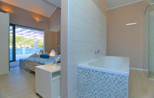 a bathroom with a tub and a bedroom with a bed at Villa Tapenade in Lastovo