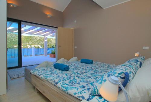 a bedroom with a bed with blue pillows on it at Villa Tapenade in Lastovo