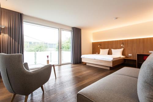 a bedroom with a bed and a large window at Storchen Restaurant Hotel in Bad Krozingen