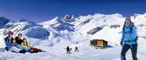 a group of people sitting on top of a snow covered mountain at Appartment Sonnenschein in Uttendorf