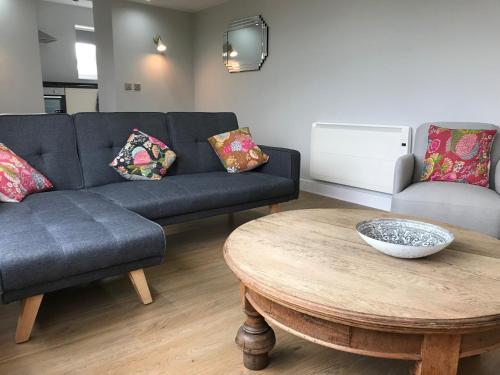 a living room with a couch and a table at The Cothi Bridge Apartments in Carmarthen