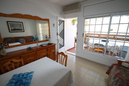 een slaapkamer met een bed en een eetkamer met uitzicht bij apartamento Kottmann in Cambrils