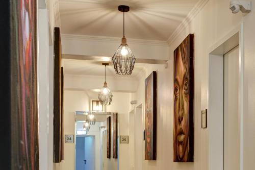 a hallway with two chandeliers hanging from a ceiling at Hotel Keese in Hamburg
