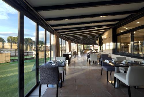 a restaurant with tables and chairs and windows at Eurostars Madrid Foro in Tres Cantos