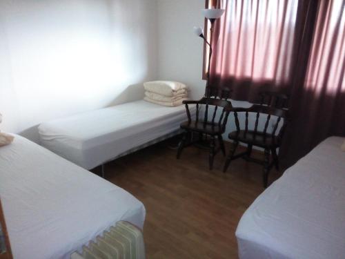 a small room with two beds and a table and chairs at Gardenview Room in Madla