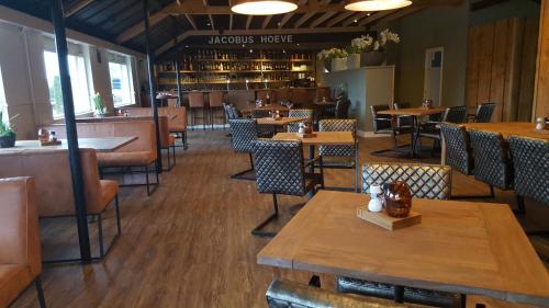 a restaurant with tables and chairs and a bar at Chalet "de Bosrand" in Stroe