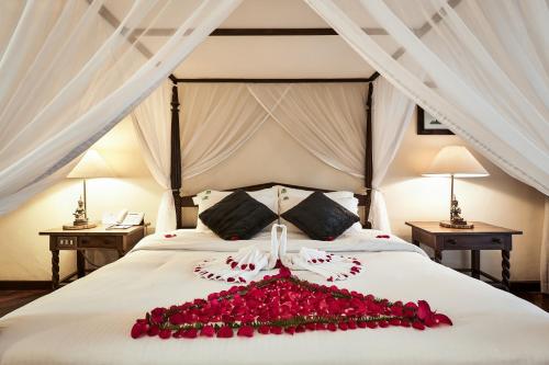 a bed with a bunch of red roses on it at Safari Park Hotel in Nairobi