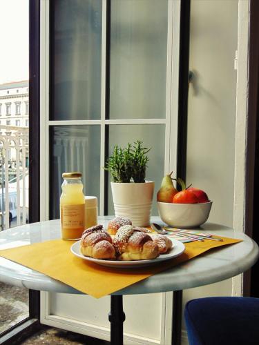 a table with a plate of donuts and apples on it at The Dante House by House In Naples in Naples