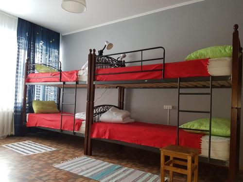 a room with three bunk beds with red sheets at Hostel 888 У Вокзала in Novosibirsk