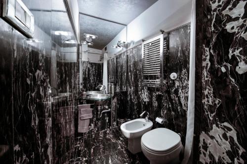 a black and white bathroom with a toilet and a sink at Turin Art Experience in Turin