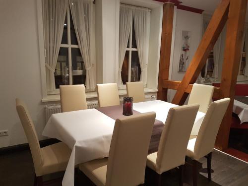 a dining room with a white table and chairs at Ratskeller Nörten in Nörten-Hardenberg