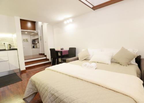 Un dormitorio con una gran cama blanca y una cocina. en Home Alex, en Roma