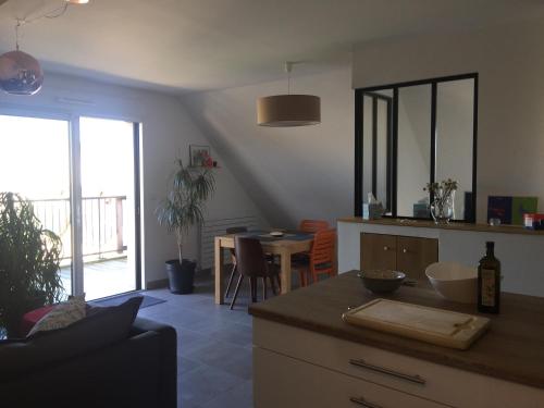 une cuisine avec un comptoir et une salle à manger avec une table dans l'établissement Charmant Appartement Saint Malo Saint Servan, à Saint-Malo