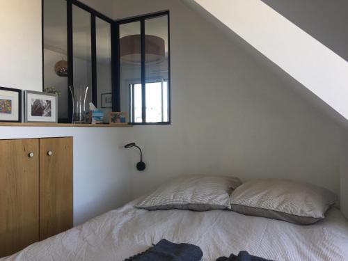 une chambre avec un lit et un miroir dans l'établissement Charmant Appartement Saint Malo Saint Servan, à Saint-Malo