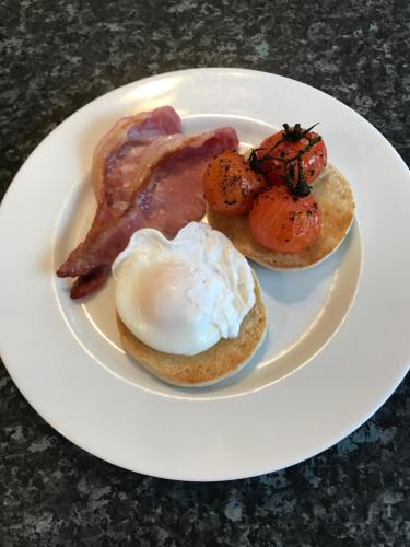 een bord ontbijt met eieren, spek en spek bij Dunelm House in Seahouses