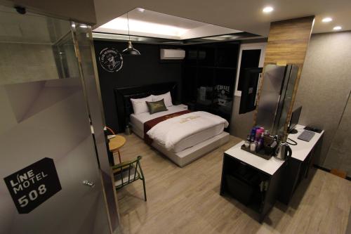 a small bedroom with a bed and a mirror at Line Motel in Daegu