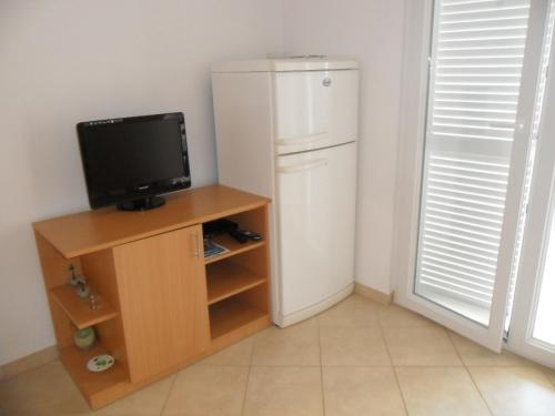 a white refrigerator and a tv in a room at Apartmani Tomičić in Malinska