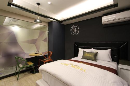 a hotel room with a bed and a table at Line Motel in Daegu