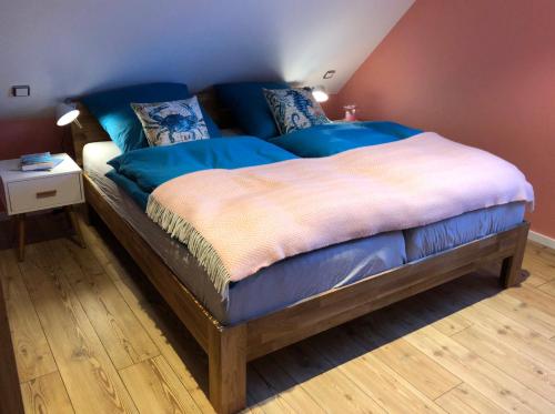 プレローにあるFerienhaus Bartiのベッドルーム1室(青いシーツが備わるベッド1台付)