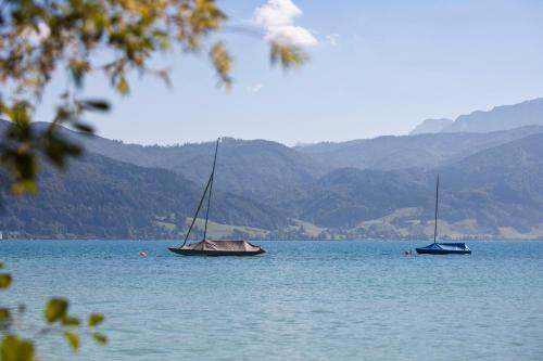 two boats sitting on a large body of water at Hotel Haberl - Attersee in Attersee am Attersee