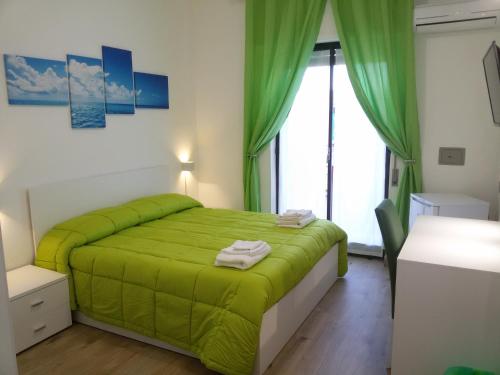 a bedroom with a green bed and a window at Hotel Elizabeth - Soverato in Soverato Marina