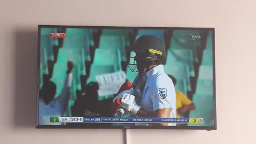 a television screen with a baseball player on it at 501 Beach Club in Mossel Bay