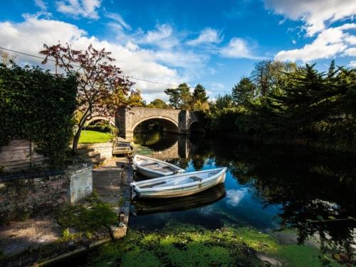two boats are docked in a river with a bridge at Bridge Hotel Brandon in Brandon