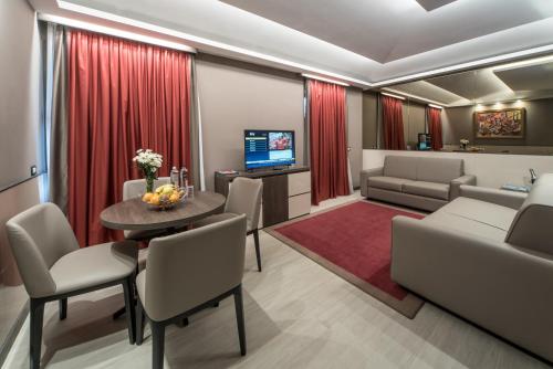 a living room with a couch and a table and chairs at Hotel Guerro in Castelvetro di Modena