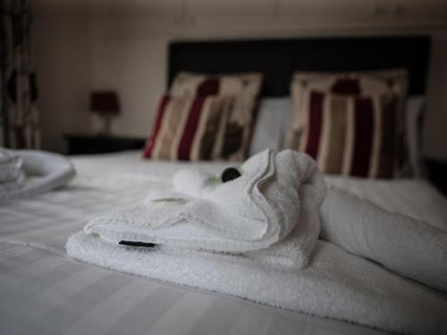 a pile of white towels on a bed at Bridge Hotel Brandon in Brandon