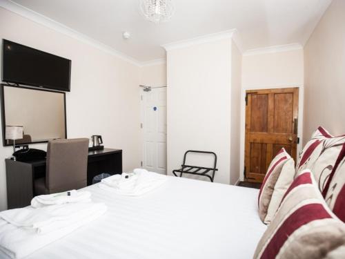 a bedroom with a bed with a desk and a television at Bridge Hotel Brandon in Brandon