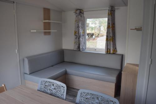 カロンザナにあるCamping Paradellaのベンチと窓付きの小さな客室です。