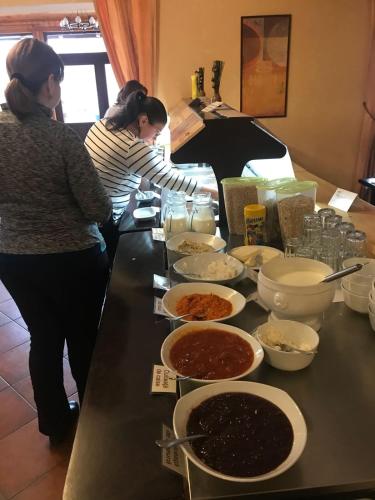 two women standing in a kitchen preparing food at Complex Pastravaria Albota in Arpaşu de Sus