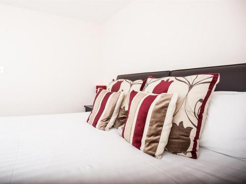 a row of pillows sitting on top of a bed at Bridge Hotel Brandon in Brandon