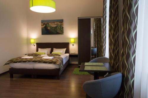 ein Schlafzimmer mit einem Bett, einem Tisch und einem Stuhl in der Unterkunft Walton Prime Apartment in Budapest