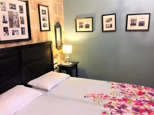 a bedroom with a bed and pictures on the wall at Luciano Valletta Boutique in Valletta