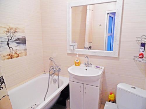 ein Badezimmer mit einem Waschbecken, einer Badewanne und einem WC in der Unterkunft Apartment on Kamyanetskaya street in Chmelnyzkyj