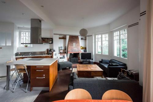 la Pinède في دينارد: مطبخ وغرفة معيشة مع أريكة وطاولة