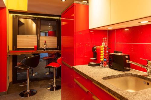 a red kitchen with a sink and red cabinets at Schirle in Zermatt
