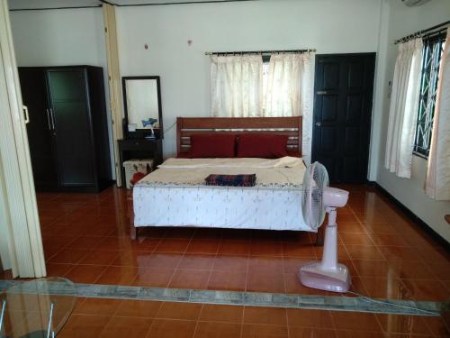 1 dormitorio con 1 cama y ventilador. en Right on the beach house en Taling Ngam Beach