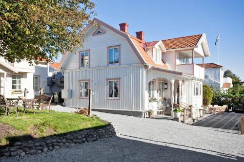 una casa blanca con una mesa y sillas frente a ella en Hotell & Restaurant Solliden en Stenungsund