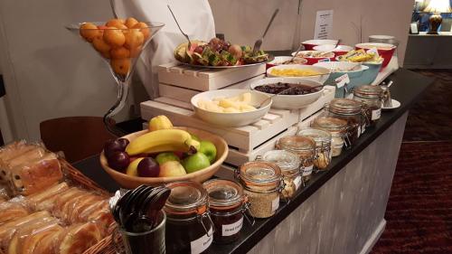 a buffet with bowls of fruit and other food at The Judds Folly Hotel, Sure Hotel Collection by Best Western in Faversham
