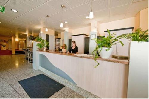 a woman sitting at a counter in a restaurant at PLAZA Hotel Bruchsal in Bruchsal